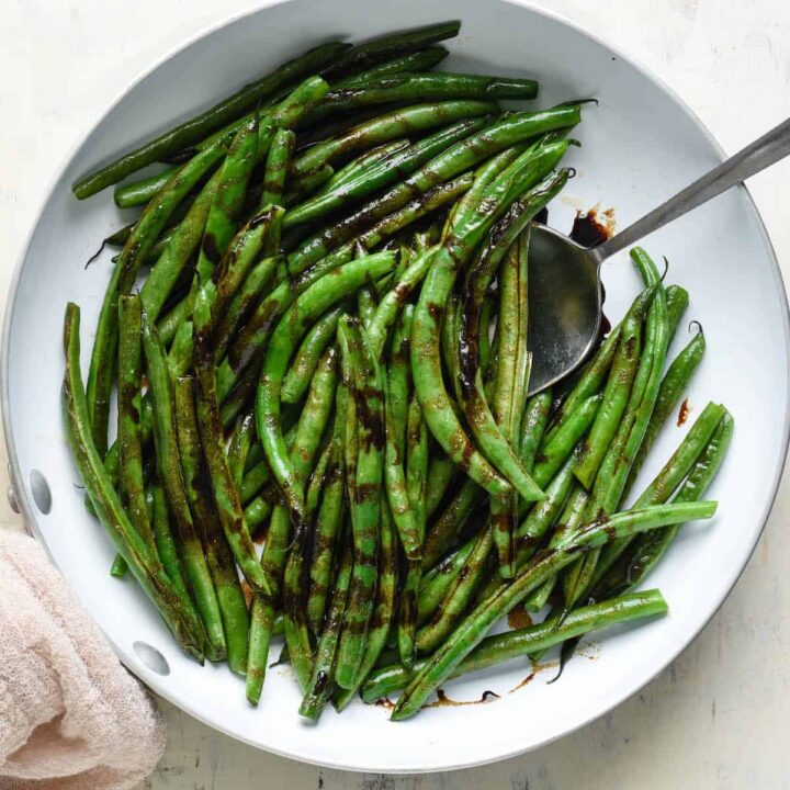 Balsamic green beans in a white skillet.