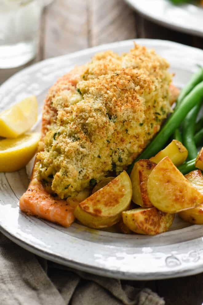 Closeup on a stuffed salmon recipe plated with green beans and potatoes.