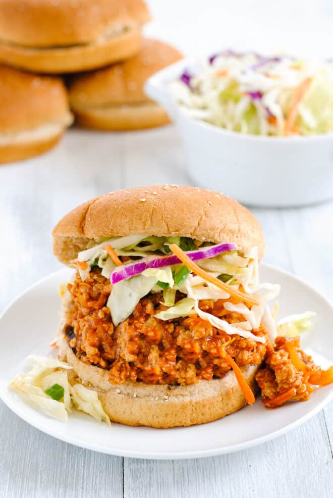 Chicken sloppy joe mixture in whole wheat bun, topped with coleslaw.