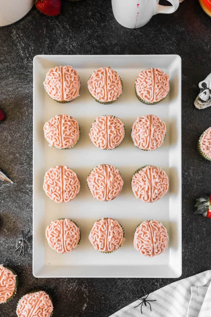 A dozen brain cupcakes on a rectangular white platter.