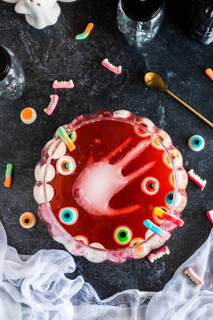 A bowl filled with easy Halloween punch and an ice hand and gummy eyeballs.
