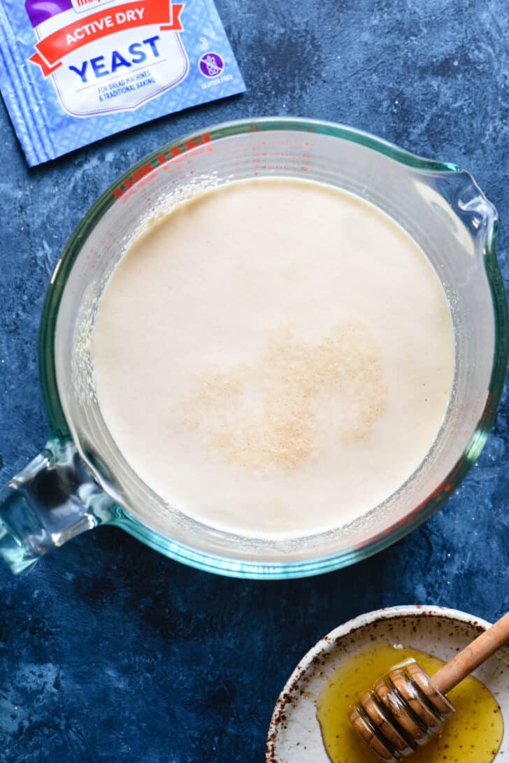 Ingredients needed for a homemade pizza dough recipe, including active dry yeast and honey.