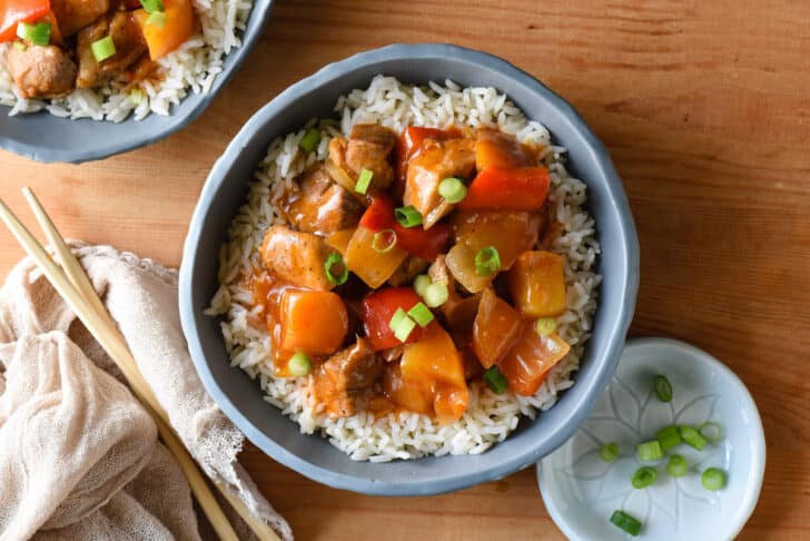 Slate blue bowl filled with white rice and Instant Pot sweet and sour chicken.