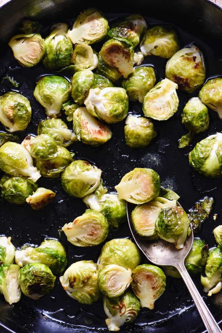 Closeup on cast iron skillet filled with maple syrup Brussels sprouts.