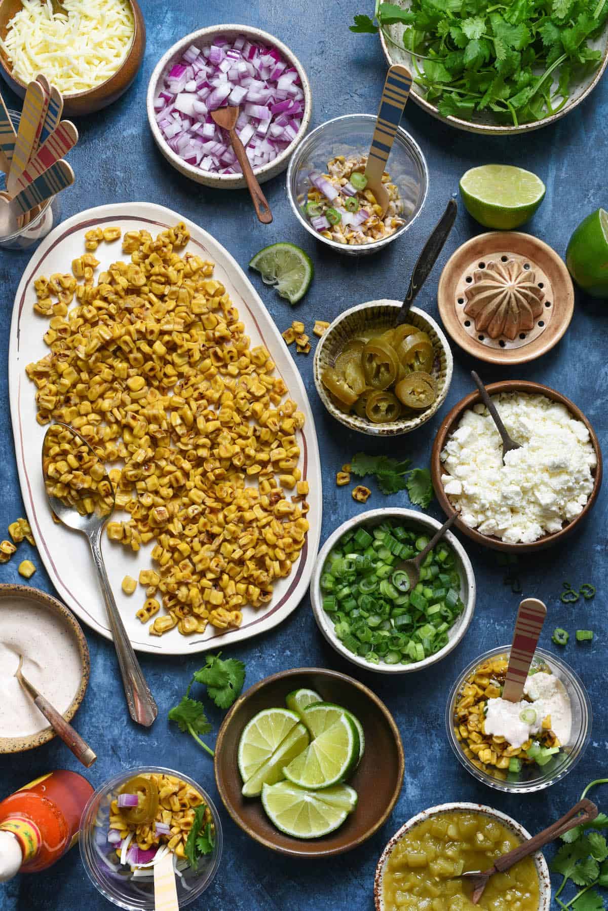 Having a fiesta? Please the whole crowd with this Mexican Street Corn Salad Bar. Gather all of the ingredients for classic Mexican street corn (elote), but let everybody assemble their own. Perfect for the spice lovers, the picky eaters, and the cilantro-adverse! | foxeslovelemons.com