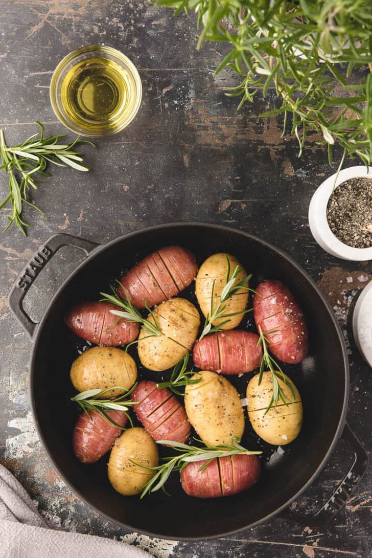 Prepped mini Hasselback potatoes in a cast iron pan ready for the oven.