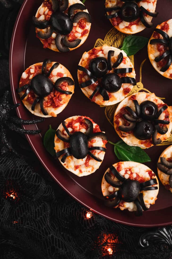 Halloween pizzas made with mini frozen pizza bagels and black olives cut to look like spiders.