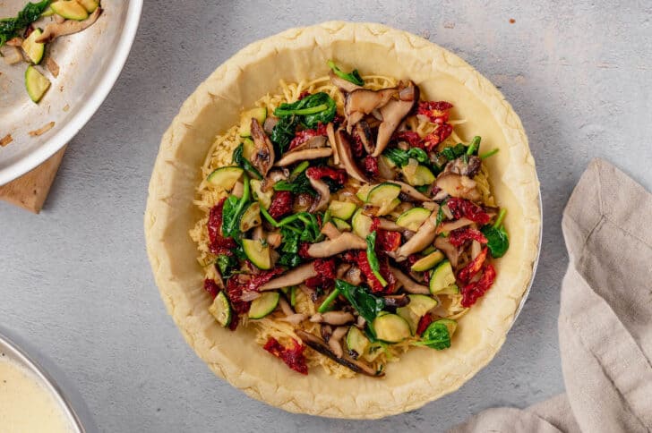 Sauteed mushrooms, shallots, zucchini and spinach in a pie shell for a vegetarian quiche.