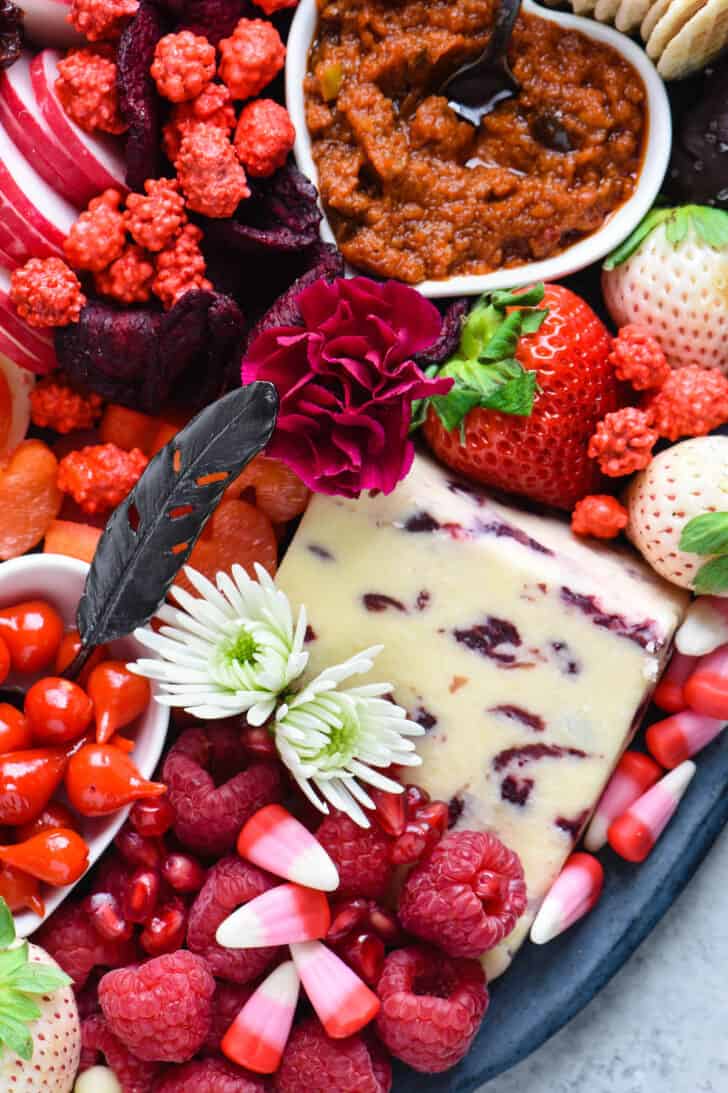 Valentine's Day party food ideas, including cheese, sundried tomato spread, strawberries, nuts and radishes.